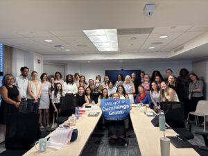 MLRI employees standing and holding a sign that says "We got a Cummings grant!"